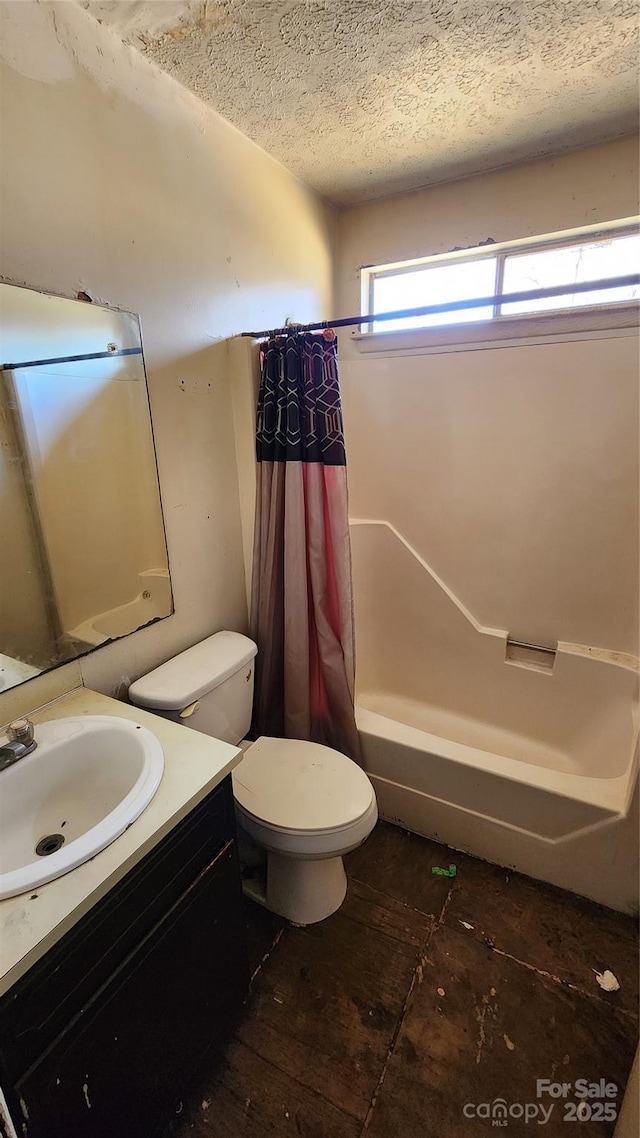 full bathroom featuring vanity, shower / bath combination with curtain, a textured ceiling, and toilet