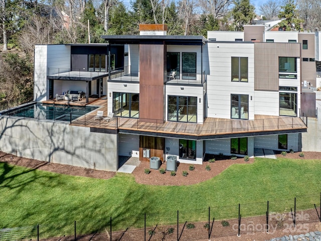 rear view of house with a yard, cooling unit, and a balcony