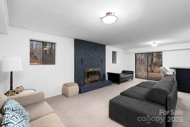 living room with a fireplace, carpet floors, and a textured ceiling