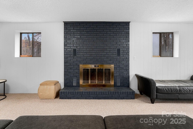 carpeted living room with a fireplace and a textured ceiling