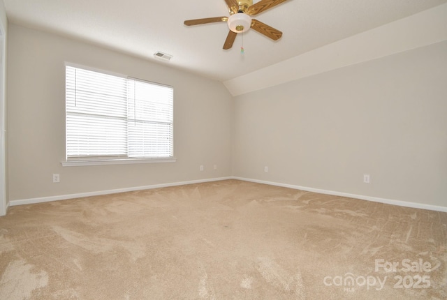 unfurnished room featuring vaulted ceiling, a healthy amount of sunlight, and light colored carpet