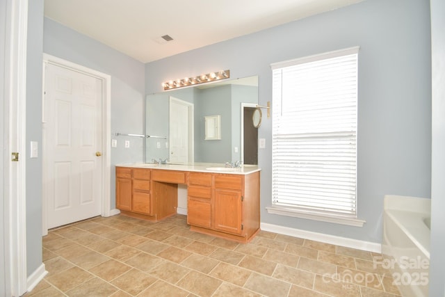 bathroom featuring a washtub and vanity