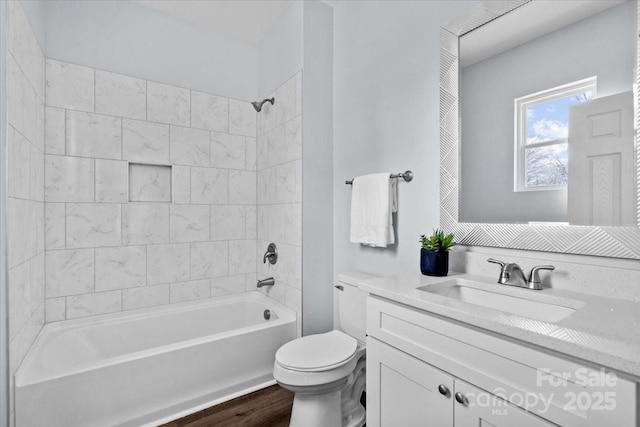 full bathroom featuring vanity, wood-type flooring, toilet, and tiled shower / bath