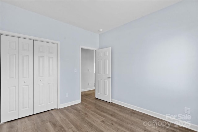 unfurnished bedroom featuring wood-type flooring and a closet