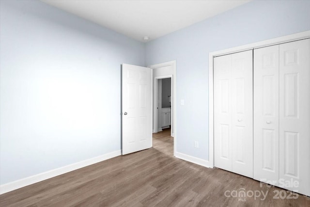 unfurnished bedroom featuring hardwood / wood-style floors and a closet