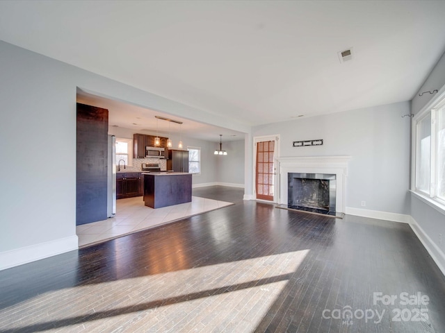 unfurnished living room featuring sink and light hardwood / wood-style floors