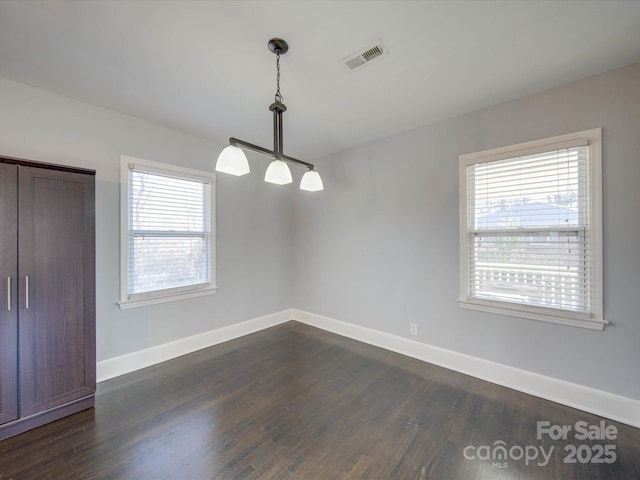 unfurnished dining area with dark hardwood / wood-style flooring and a wealth of natural light