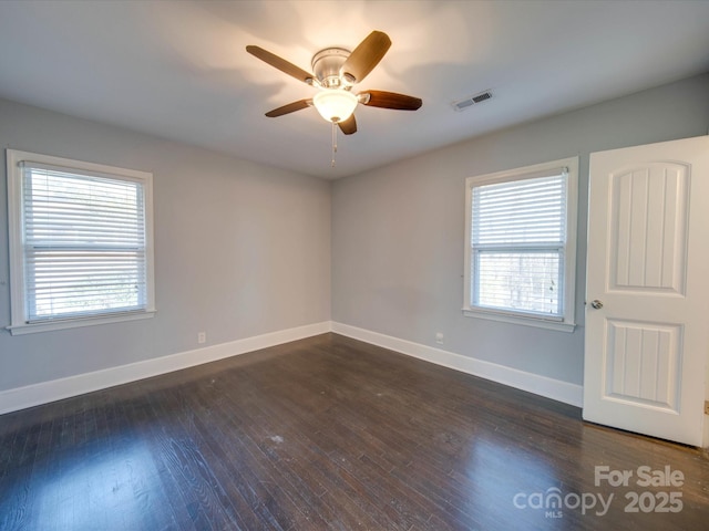 empty room featuring dark wood-type flooring and ceiling fan