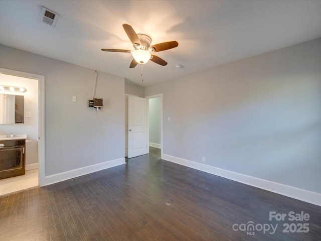 empty room featuring dark wood-type flooring, sink, and ceiling fan