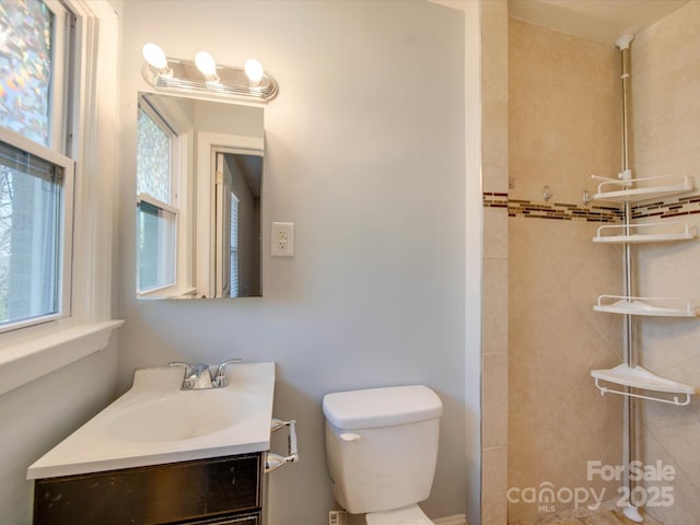 bathroom with vanity, plenty of natural light, and toilet