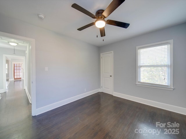 empty room with ceiling fan and dark hardwood / wood-style flooring