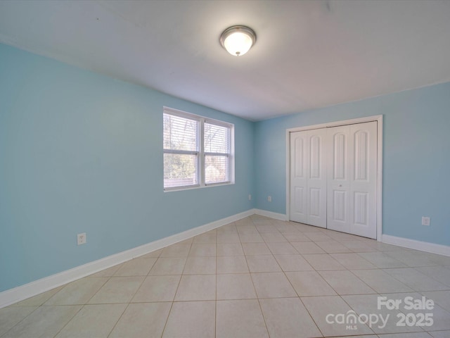 unfurnished bedroom with light tile patterned flooring and a closet