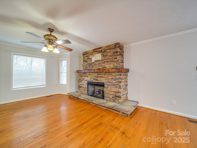 unfurnished living room featuring hardwood / wood-style flooring, a fireplace, ornamental molding, and ceiling fan