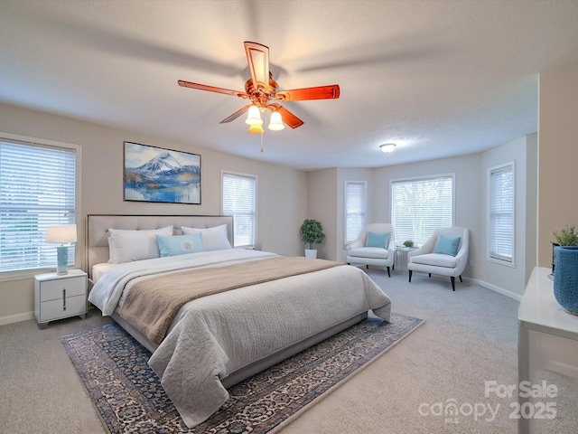 bedroom with ceiling fan, light colored carpet, and multiple windows