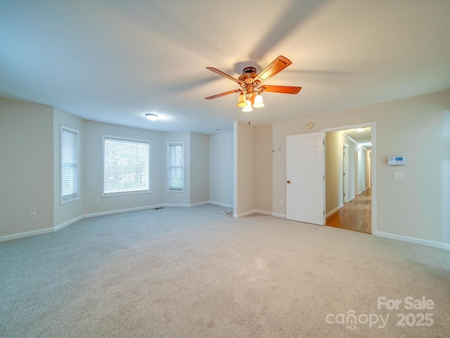 carpeted spare room featuring ceiling fan