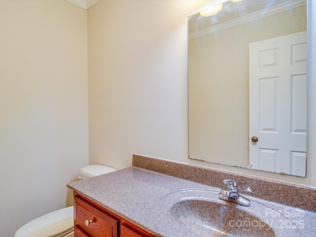 bathroom featuring ornamental molding, vanity, and toilet