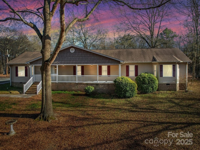 single story home featuring covered porch and a lawn