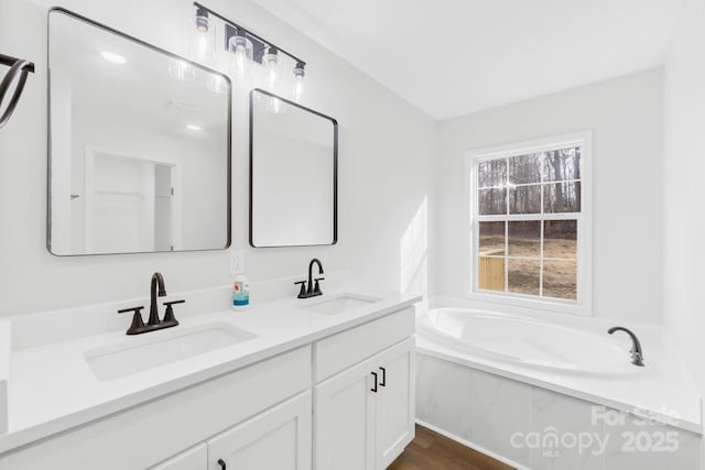 bathroom with vanity and a tub