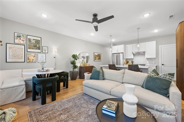 living room featuring ceiling fan and light hardwood / wood-style flooring