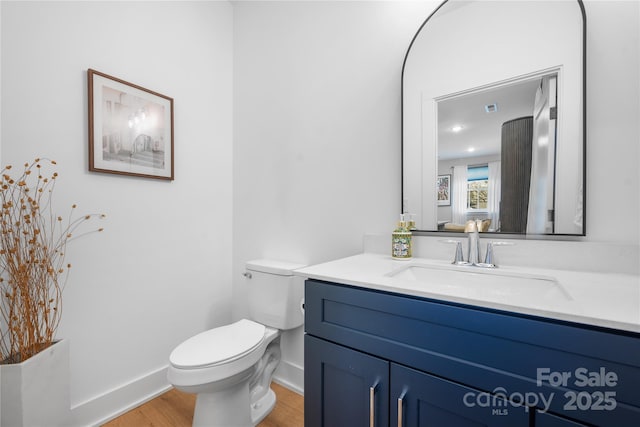 bathroom featuring hardwood / wood-style flooring, vanity, and toilet