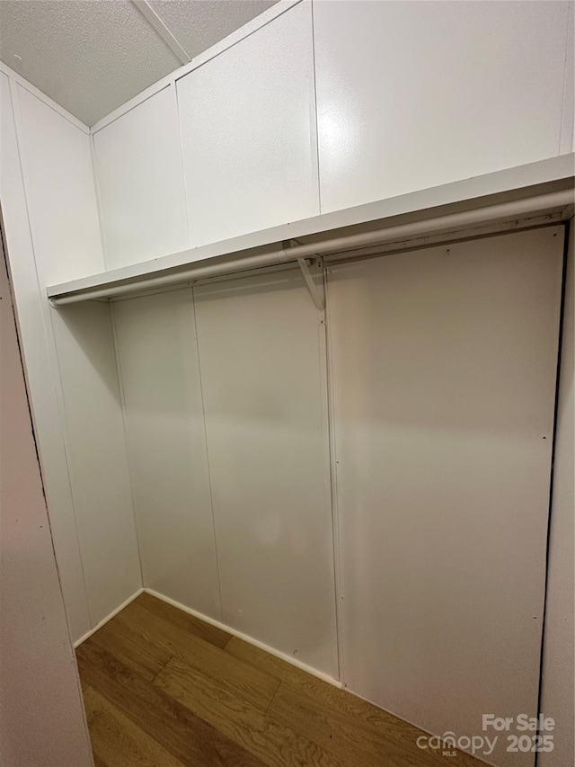 walk in closet with dark wood-type flooring