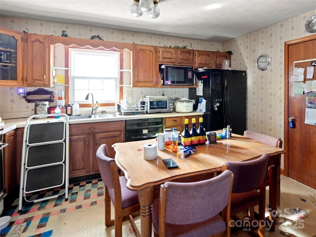 kitchen featuring sink, black appliances, and a textured ceiling