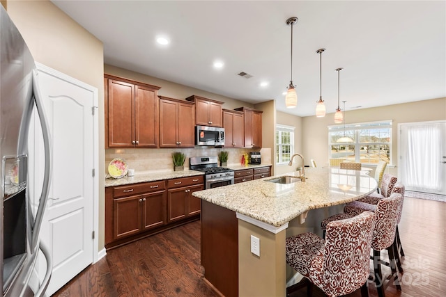 1605 Appledale Ct Unit 116, Fort Mill, SC 29715 - kitchen with appliances with stainless steel finishes, a sink, dark wood-style flooring, a kitchen bar, and decorative backsplash