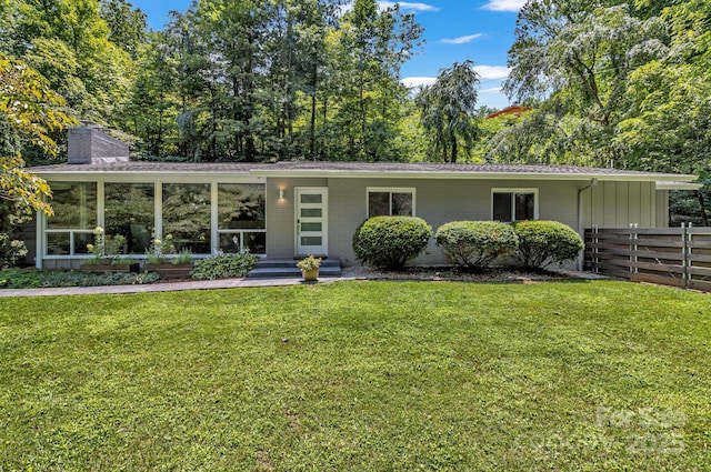 view of front of home featuring a sunroom and a front yard