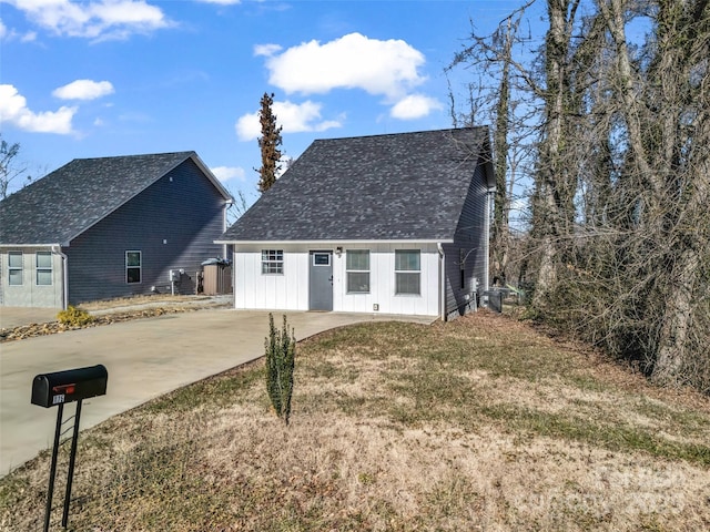 view of front of home with roof with shingles and concrete driveway