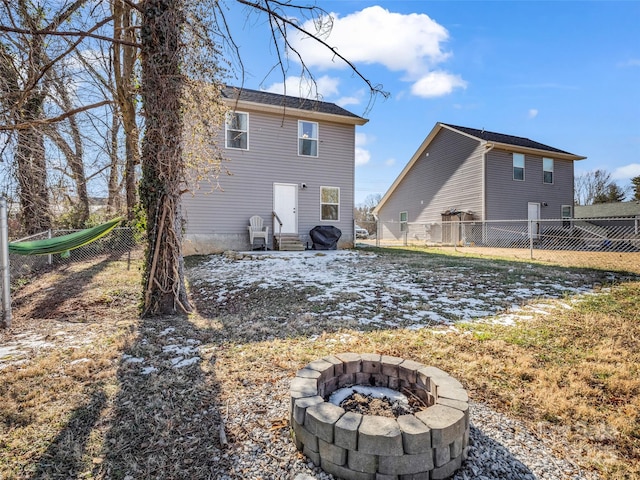 back of house with a fire pit