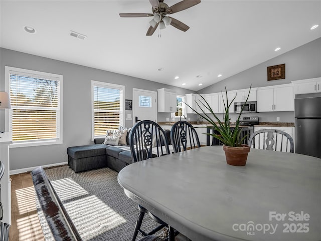 dining room with lofted ceiling, hardwood / wood-style floors, and ceiling fan