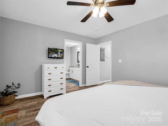 bedroom with dark wood-type flooring, ceiling fan, electric panel, and ensuite bath