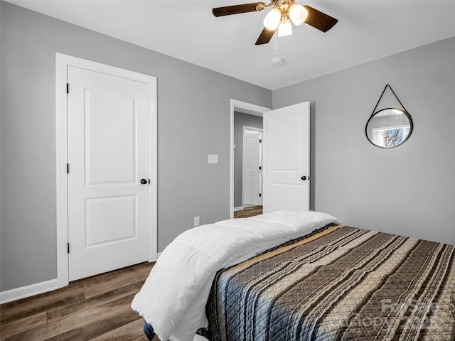 bedroom with dark hardwood / wood-style floors and ceiling fan