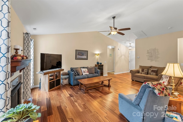 living room featuring ceiling fan, wood-type flooring, and vaulted ceiling