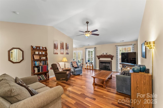 living room with wood-type flooring, lofted ceiling, and ceiling fan