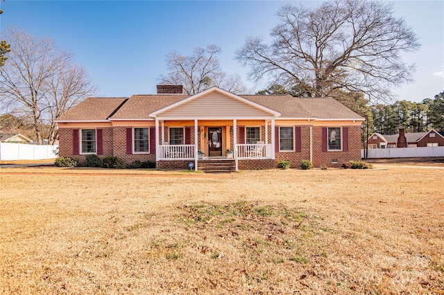 ranch-style home featuring a porch and a front yard