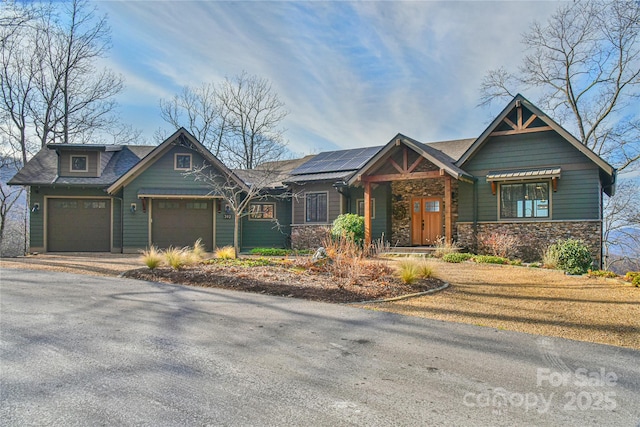 craftsman house with a garage and solar panels