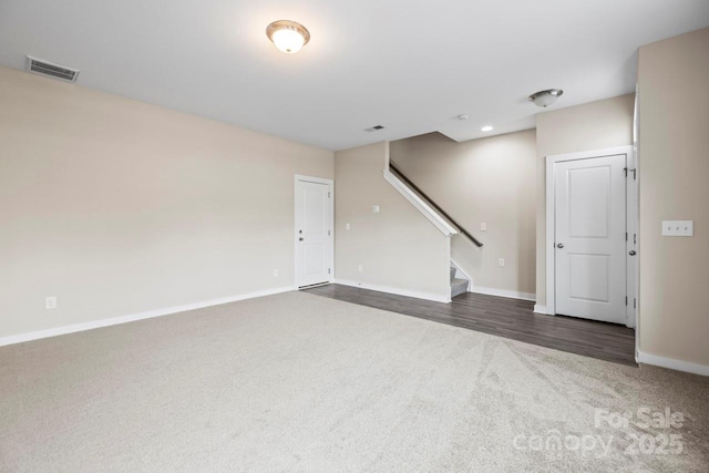 unfurnished room featuring recessed lighting, visible vents, baseboards, stairway, and dark colored carpet