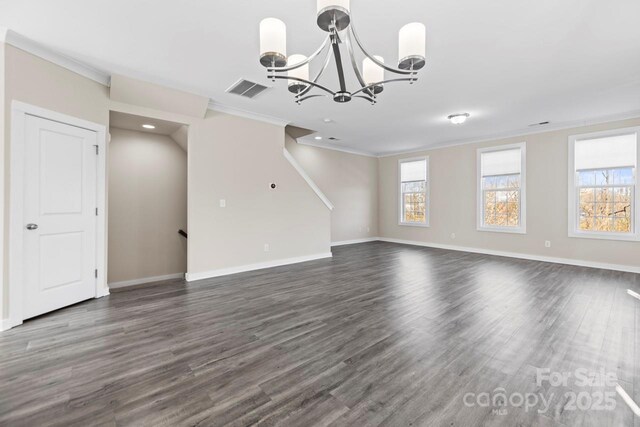 unfurnished living room with baseboards, visible vents, ornamental molding, dark wood-type flooring, and a notable chandelier