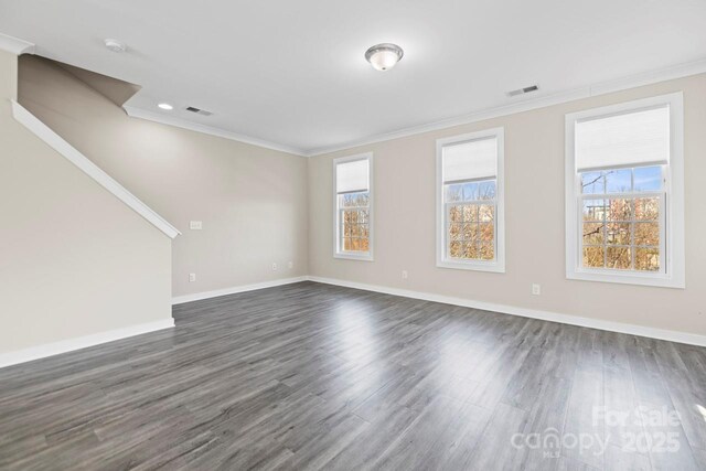 unfurnished living room featuring a healthy amount of sunlight, visible vents, and crown molding