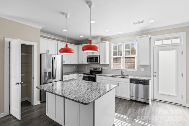 kitchen featuring appliances with stainless steel finishes, pendant lighting, and white cabinetry