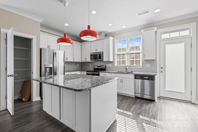 kitchen featuring dark stone counters, stainless steel appliances, visible vents, and white cabinetry