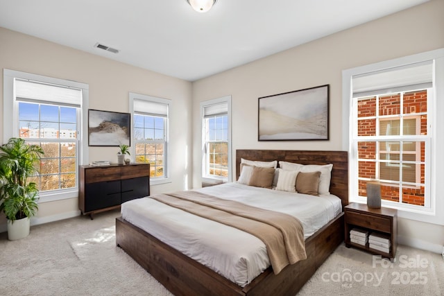 bedroom with light colored carpet, visible vents, and baseboards