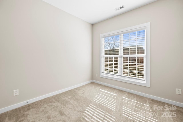 empty room with light colored carpet, visible vents, and baseboards