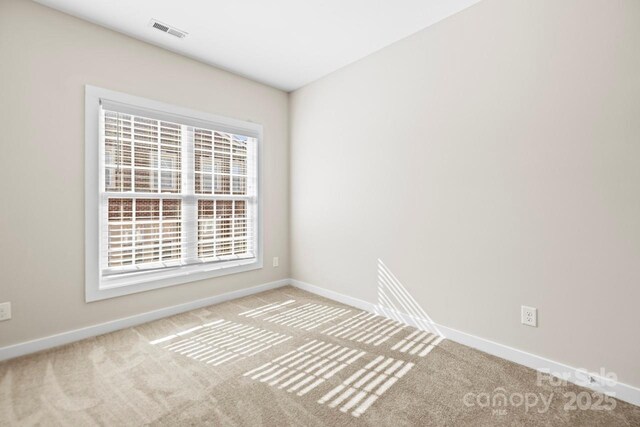 unfurnished room featuring light carpet, visible vents, and baseboards