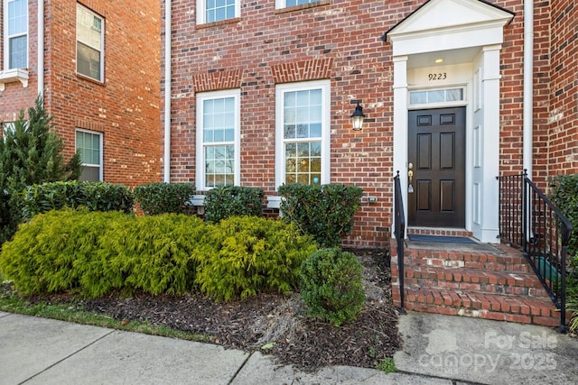 view of exterior entry with brick siding