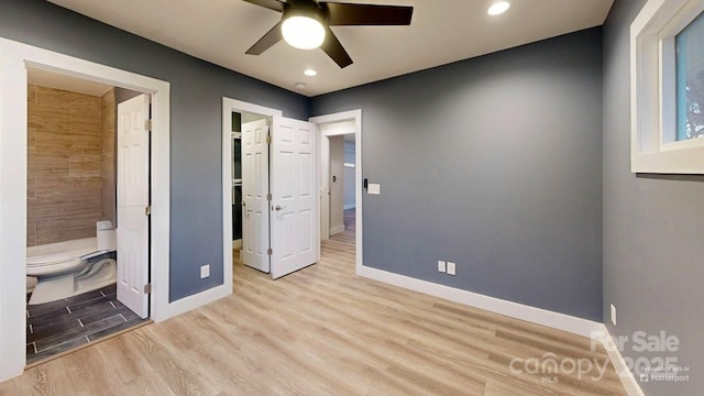 unfurnished bedroom with ensuite bath, ceiling fan, and light wood-type flooring