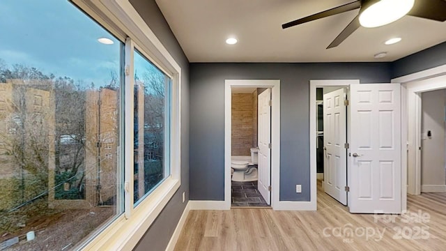 unfurnished bedroom featuring ensuite bathroom, ceiling fan, and light hardwood / wood-style flooring