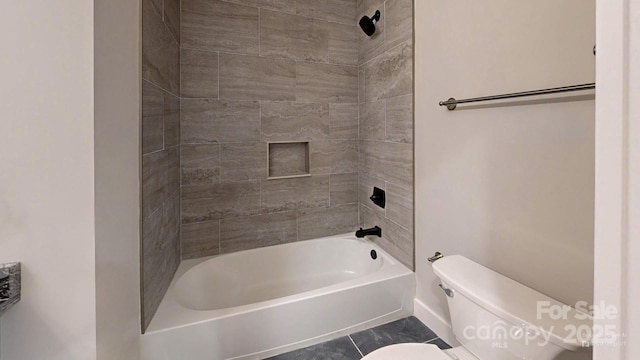 bathroom featuring toilet, tiled shower / bath combo, and tile patterned flooring