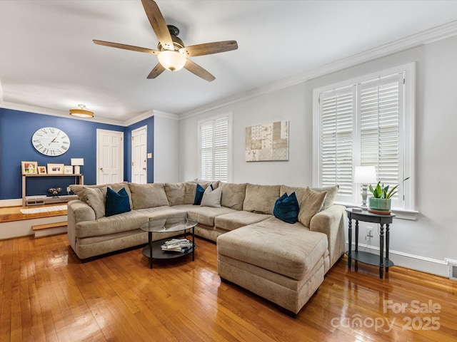 living room with hardwood / wood-style flooring, crown molding, and ceiling fan